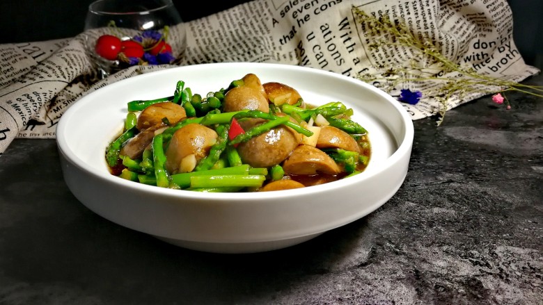 蚝油草菇炒芦笋,炒均匀后加入稀释后的蚝油,然后是和鸡精翻炒均匀。这时芦笋内心也变得油润了,时间不能太长长了芦笋会变老失去光泽和色相,口感也会变差。关火!拍照后就可以享用了。