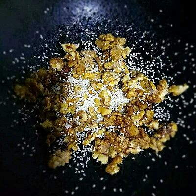 琥珀核桃仁,关火,倒入芝麻快速翻拌均匀即可