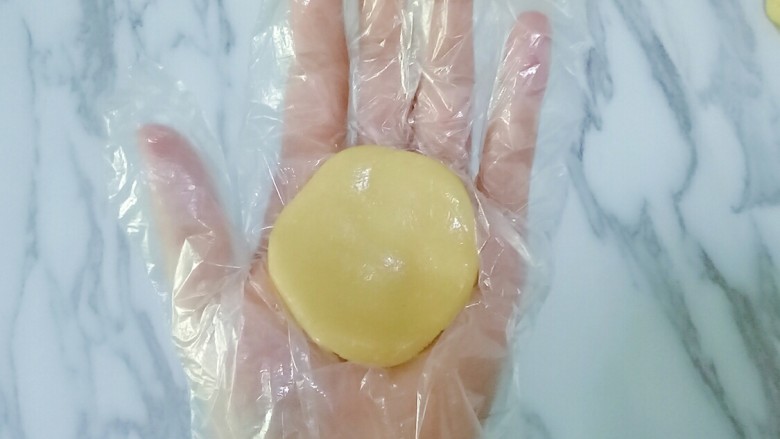 五仁月饼,取一块皮放在手心按扁,(我带的一次性手套嫌带手套不好操作的在手上拍点熟面粉防粘)
