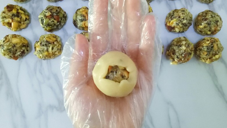 五仁月饼,慢慢的推动面皮,使皮包裹在馅上