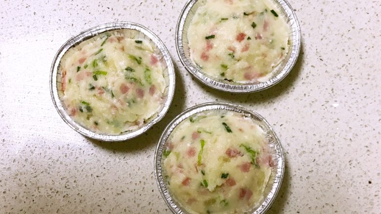 芝士火腿土豆泥,把火腿土豆泥加入锡纸杯中,轻轻压实