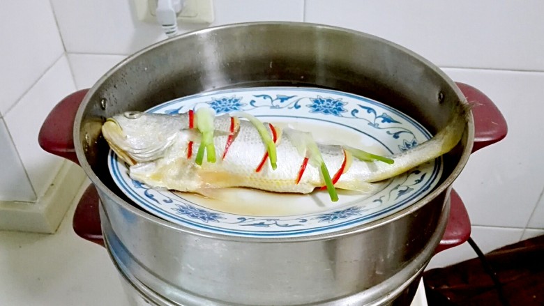 披红戴绿的蒜香红辣椒蒸黄鱼,放葱白,淋<a style='color:red;display:inline-block;' href='/shicai/ 718'>料酒</a>,蒸锅水开放进去蒸八分钟焖三分钟