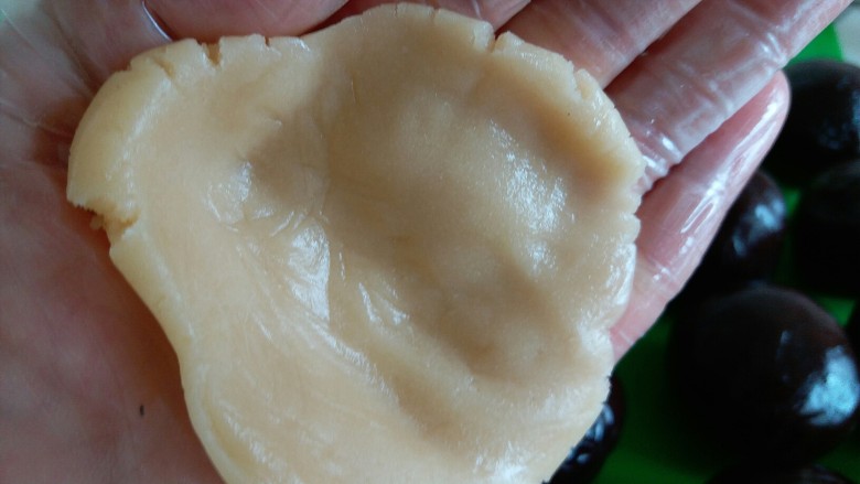 63克广式豆沙月饼,戴上食品手套,面团在手心按扁