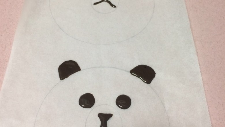 #甜味#布朗胖熊焦糖布丁,裱花袋剪一个小小的口子,然后把油纸翻过来背面,按照图形把眼睛,鼻子,耳朵做好,做的稍厚不要特别薄,而且这个耳朵下面应该再多出一个尖尖,那样容易装在布丁上