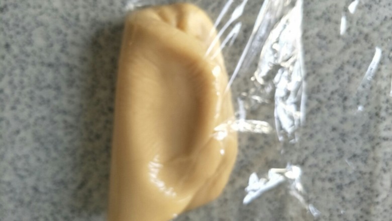 蜂蜜五仁、豆沙馅月饼,把面倒入保鲜膜上,用保鲜膜上下左右折叠两次,便于液体材料与面粉混合均匀