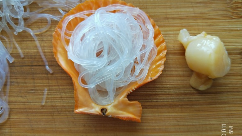 蒜蓉粉丝蒸扇贝,取适量粉丝放在壳里,粉丝不能太多