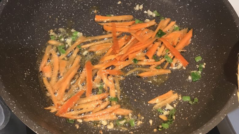 炒杂菜,油锅中下蒜末葱末炒香,入胡萝卜丝翻炒