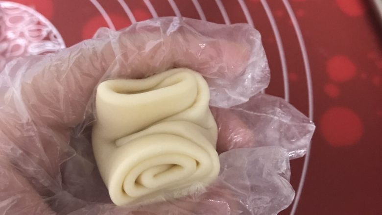 麻薯肉松蛋黄酥,取一个静置好的面团,两头往中间捏,压扁