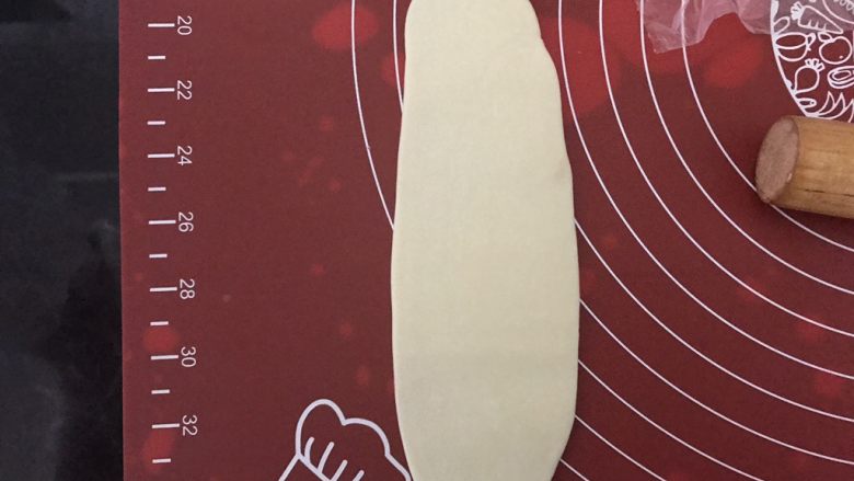 麻薯肉松蛋黄酥,取静置好的面团,收口朝上压扁,用擀面杖朝上下两个方向擀长