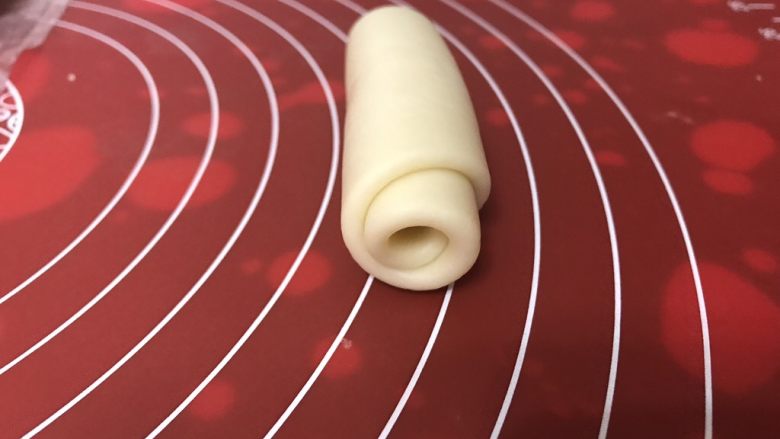 玫瑰鲜花饼,由上向下轻轻卷起,收口向下,依次做好剩下的,收口向下摆好,盖上保鲜膜静置15-20分钟。