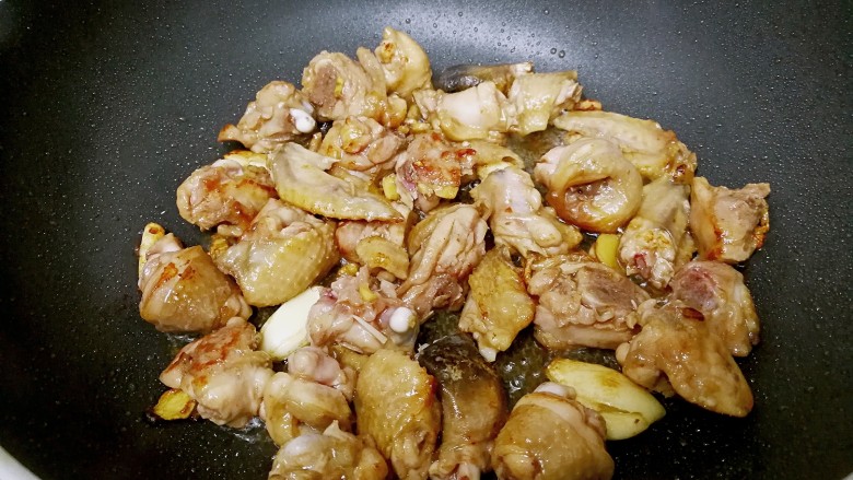 栗子焖鸡,颠锅把鸡块翻面,大火烧至出现焦黄色。