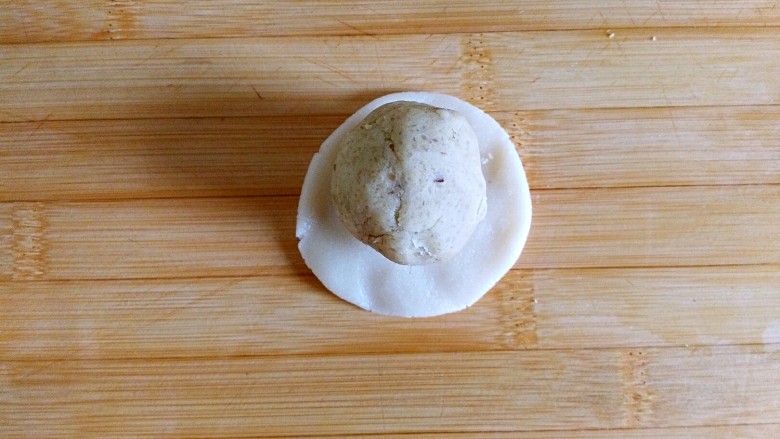 团圆最长情的告白——
广式栗蓉月饼,一份为例
（应该在手里操作，碍于菜谱要求严格，再面板操作）
首先取一份饼皮，捏扁，放入栗蓉

建议带一次性手套操作，不然会比较粘手