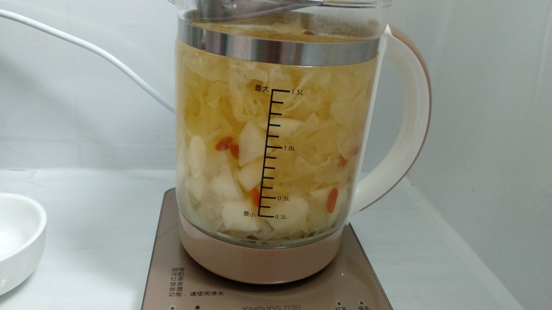 雪梨银耳汤,用勺子搅动一下,这时盖子要倾斜盖以防液体溢出,直至结束。