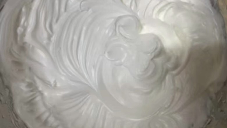 南瓜泥海绵纸杯蛋糕,蛋清分三次加入剩余的白糖打发,打至湿性偏硬。