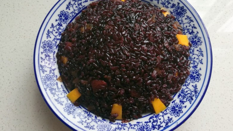 金瓜黑米饭,然后用勺子把蒸好的黑米饭填入碗中,填满压实,再放入蒸锅中蒸约8~10分钟即好;