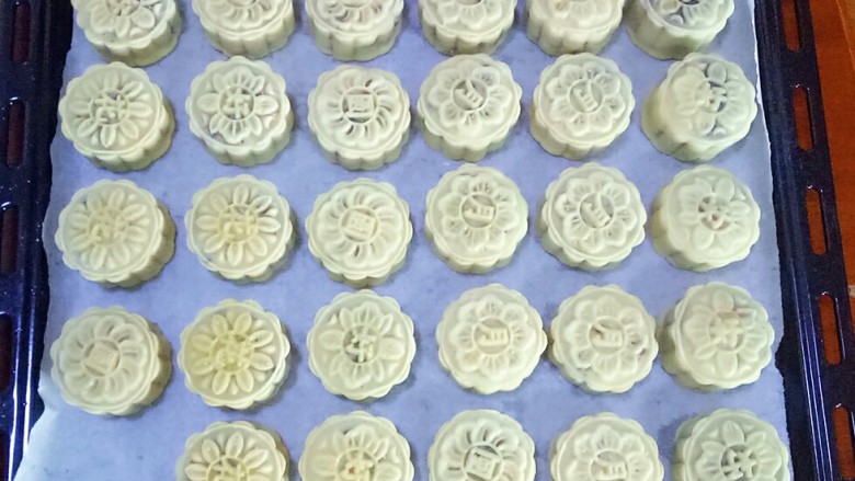 五仁月饼,压出月饼形状,转移到烤盘上,炒面喷一点水