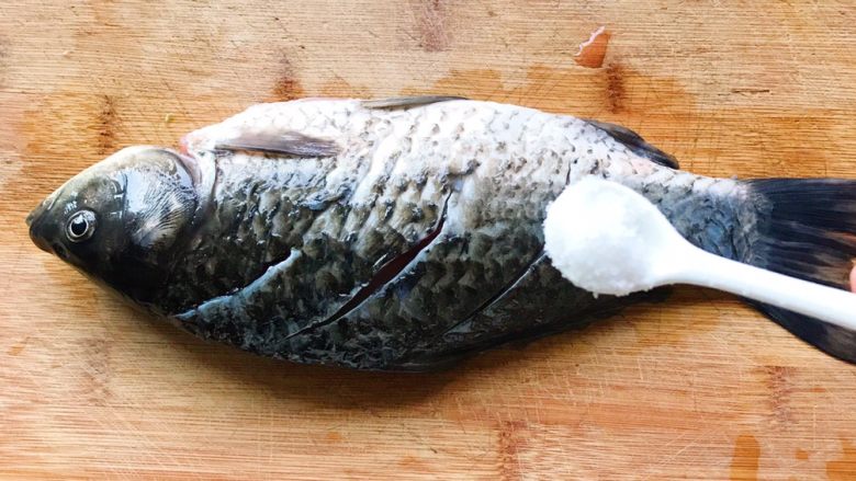 浓汤鲫鱼炖豆腐,用少量盐抹在鱼身上,翻面也抹上