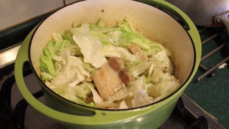 葡萄酒醋炖猪肉高丽菜,放入用手撕碎的高丽菜叶,将高丽菜也炒软。