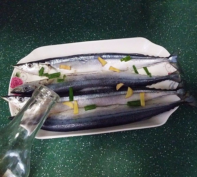 豆豉辣酱蒸秋刀鱼,放入盘中:加食盐、葱姜和料酒抹匀、腌制半小时左右后冲洗干净