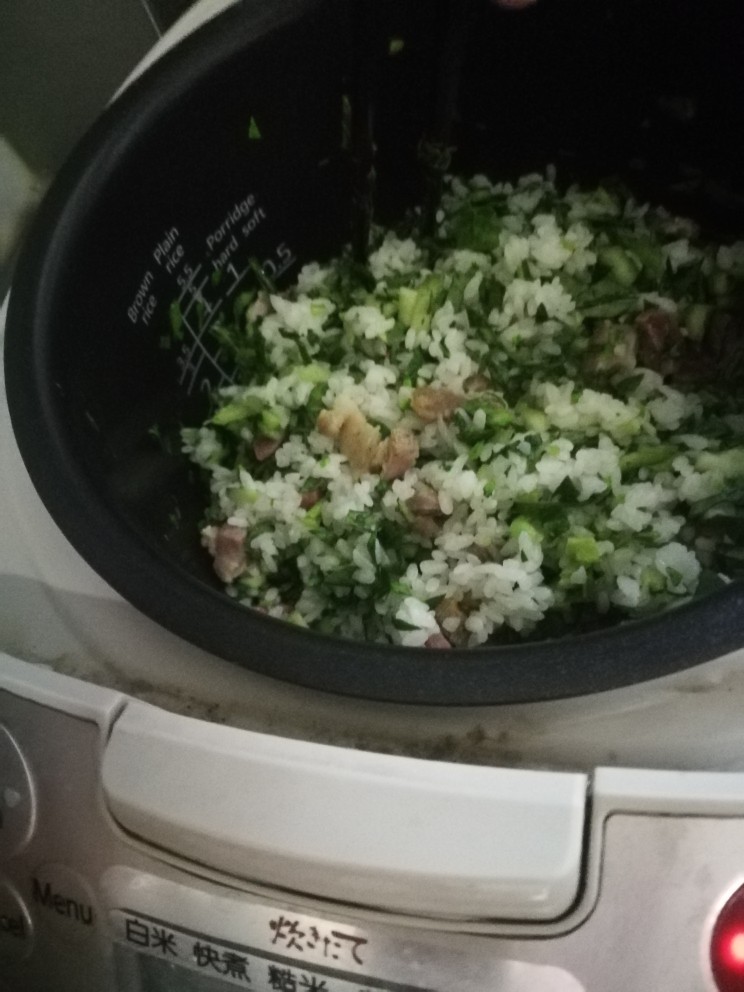 猪油咸肉香肠菜饭,到差不多还有一刻钟左右的时间时把青菜碎倒入锅里。(也可以青菜稍微煸炒后加入)