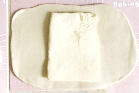 万能千层酥皮,面皮擀好后,从冰箱取出一片黄油,将黄油摆放在面皮的中间位置