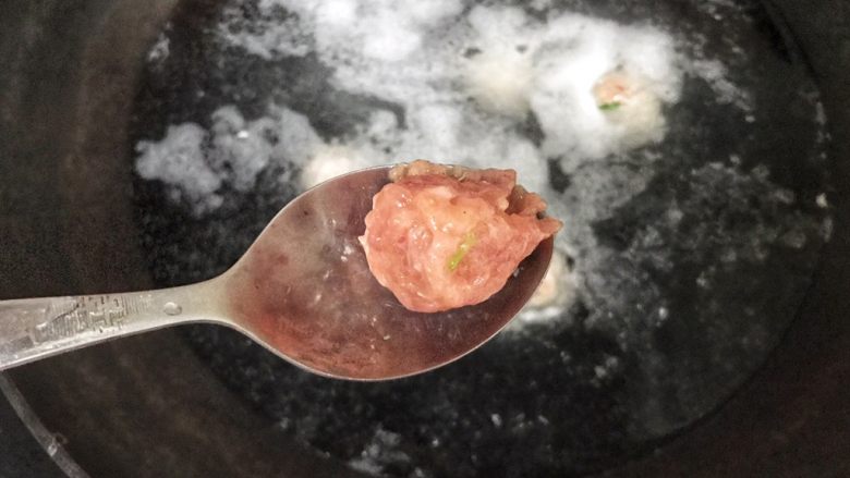 超级鲜美无敌肉丸靓汤,用勺子攥一下了料酒,再托住肉丸,投入锅中,速度要快,否则前面投入的肉丸都煮老了,后面的还不熟呢