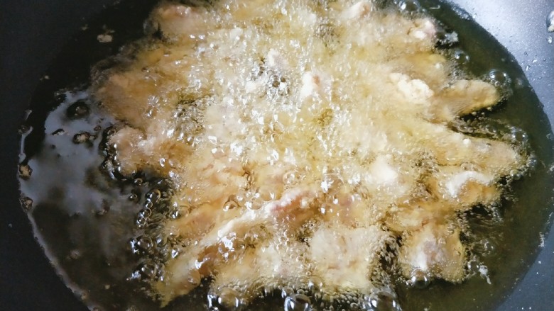 菠萝咕噜肉,锅中放油,最好用深点的锅,比较省油。
油热后放入肉块炸。
