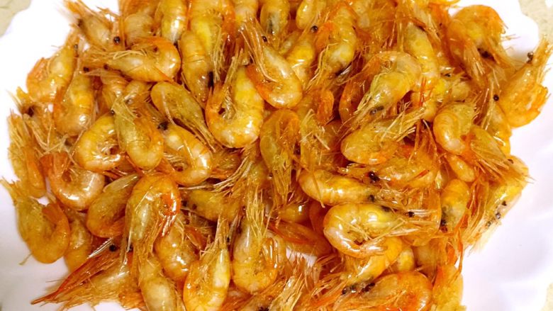 油爆小河虾,锅里油再次烧热至200度左右,下入小河虾复炸,使虾肉与虾壳脱开,用漏勺捞出备用。