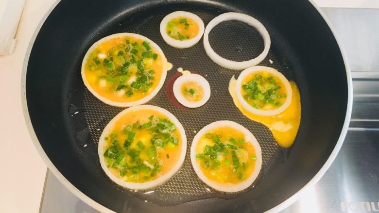 洋葱圈鸡蛋饼,用勺子淋入鸡蛋液,不能太满,七八分即可,多了翻面的时就会溢出来