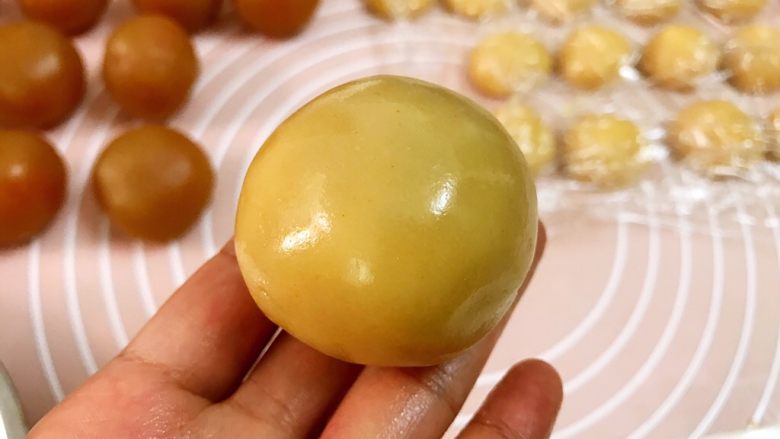广式低糖莲蓉蛋黄月饼,慢慢收口滚圆,放入干粉中滚一圈防粘