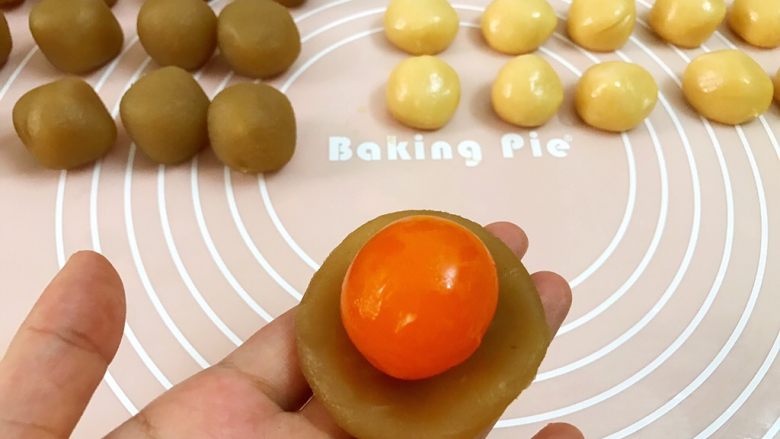 广式低糖莲蓉蛋黄月饼,取一份莲蓉馅压扁,放入一整个蛋黄