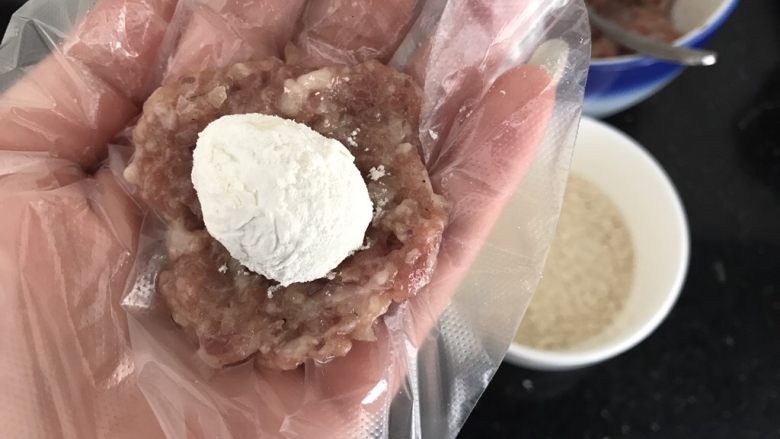 内有乾坤的肉丸子~苏格兰蛋,挖一勺肉末,手掌中间压平,把沾上面粉的鹌鹑蛋放在肉末中间