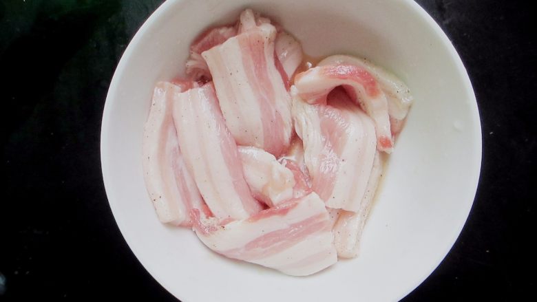 雪碧五花肉,把五花肉放入碗里,倒入适量雪碧和一点点黑胡椒粉腌制一小时