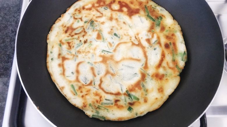 早餐+鲜贝韭菜饼,当一面煎至金黄色后,翻面再来煎另一面,