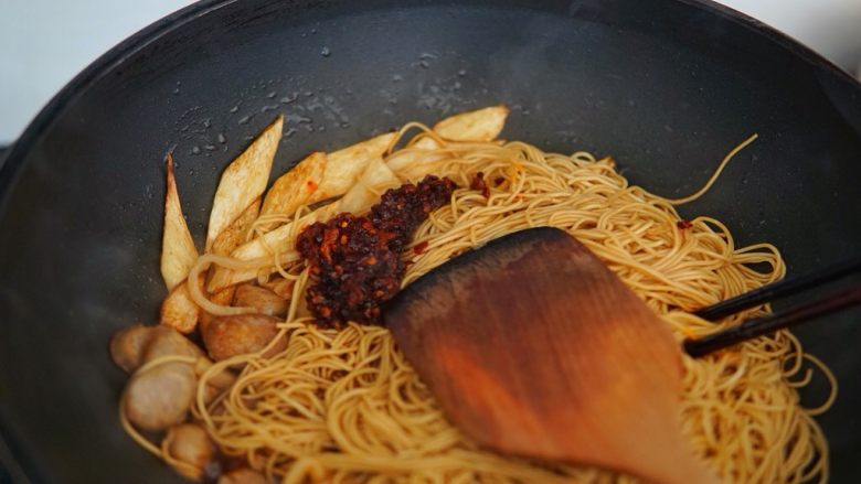 早餐+芦笋香肠炒面,老干妈放入锅内,继续翻炒