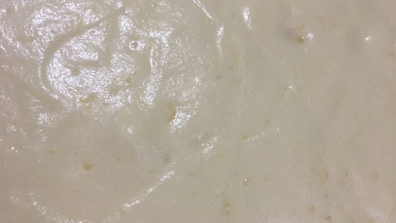 蜜豆奶油蛋糕卷,拌匀好的糊慢慢倒入提前铺好油纸的烤盘中,摔几下震出大气泡。烤箱180度预热