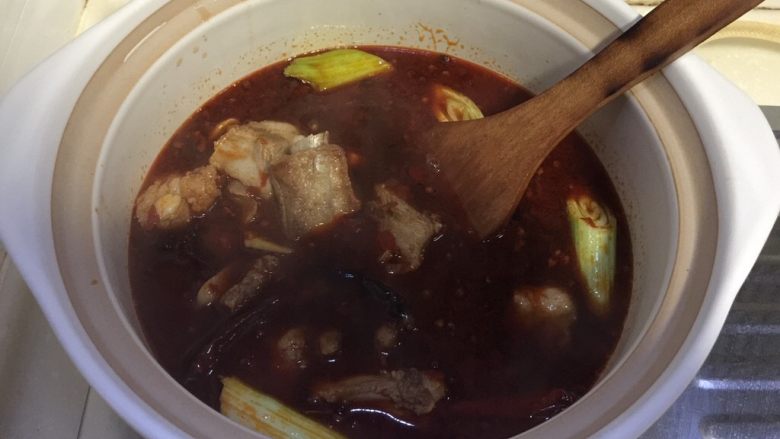 辣冬瓜排骨煲,转移入一大砂煲中,没有砂锅的亲也可用自家的炒锅或其他汤锅,我觉得砂锅或铸铁锅炖出来更香,烧开后转小火慢炖