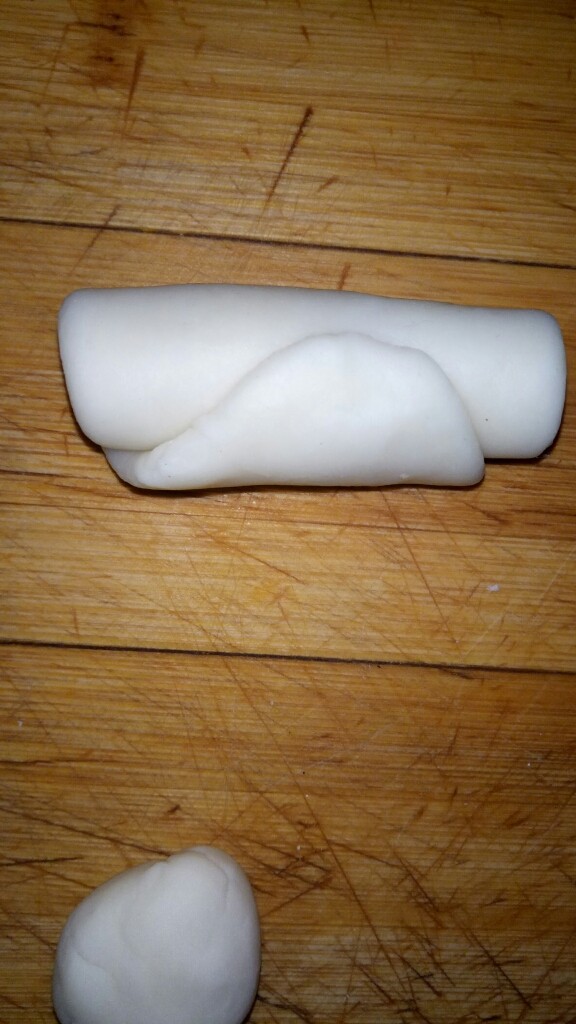 椒盐酥,由一头卷起,全部弄好以后盖笼布醒15分钟。然后再用擀面杖擀细长条一次,然后卷起来