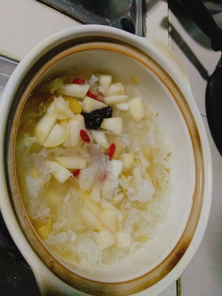 爱上银耳的小吊梨汤,开锅放入梨丁,梅子,大部分的枸杞,转成小火,熬上一个小时左右。