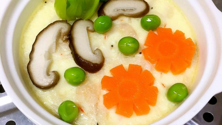 宝宝蒸蛋,表面蛋液即将凝固时摆好处理好的油菜、香菇、胡萝卜、虾皮再蒸1分钟出锅；淋一些黑芝麻亚麻籽油、撒一点黑芝麻核桃粉提味即可。