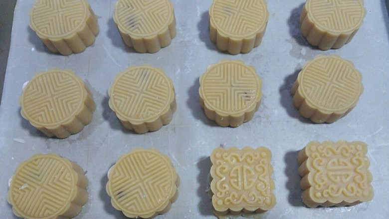 蔓越莓绿豆馅月饼(内附馅料做法),
依次压制完所有月饼胚,表面喷微量清水,再放入预热好的烤箱先烤4~5分钟定型;