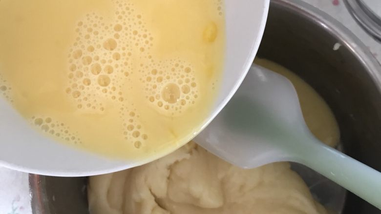 经典榴莲泡芙,先倒入三分之一的蛋液,刮刀翻拌均匀后再加后三分之一的蛋液。
