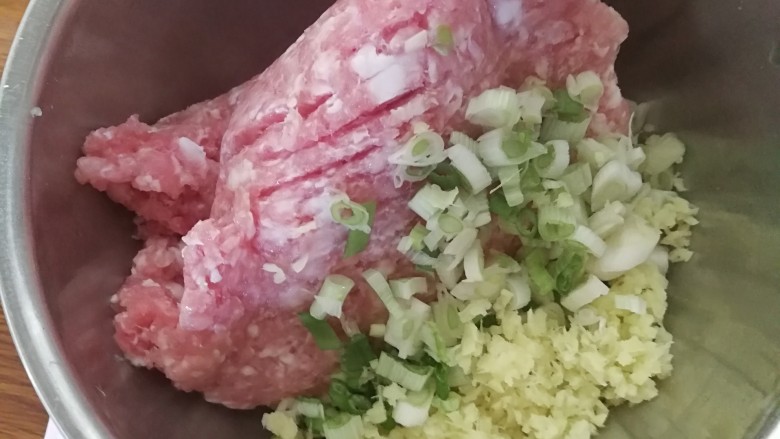 全芹菜猪肉馅饺子,将切好的瘦肉,葱姜末放在一个盆里。