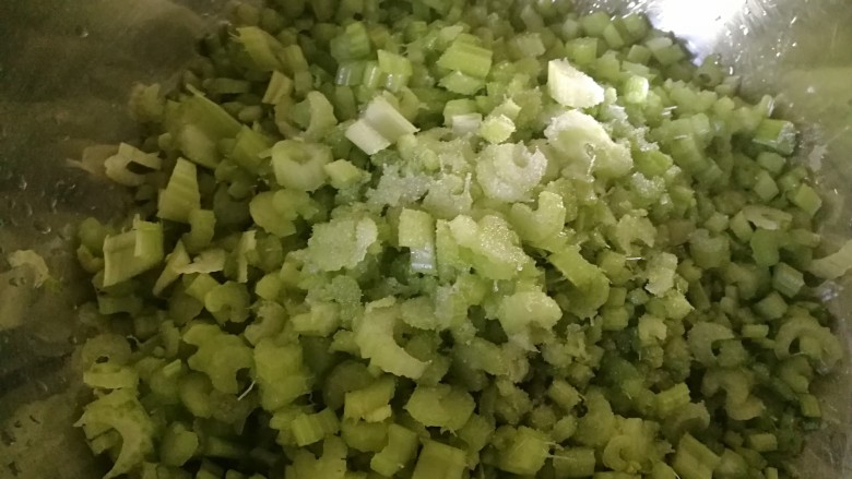 全芹菜猪肉馅饺子,放到盆里加一点盐,将芹菜水煞出。用手抓一抓。