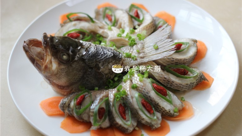 孔雀开屏鱼,胡萝卜片垫底下,上面摆撒葱花,放上枸杞