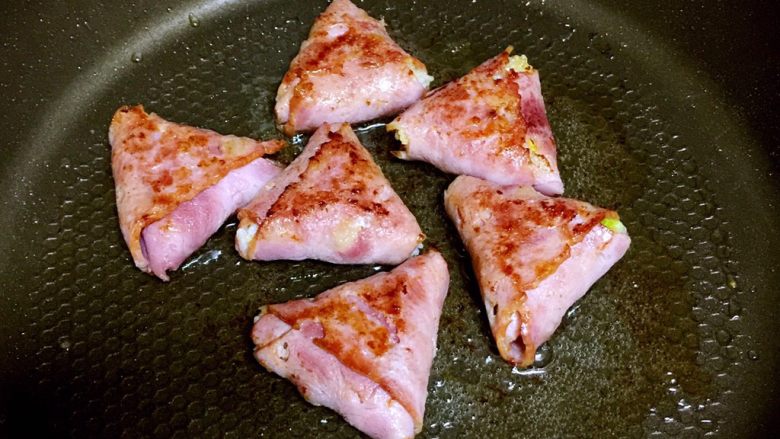 培根包饭—小小炒饭的另一种高大上吃法,一面煎好了翻面,盖上锅盖小火继续煎。