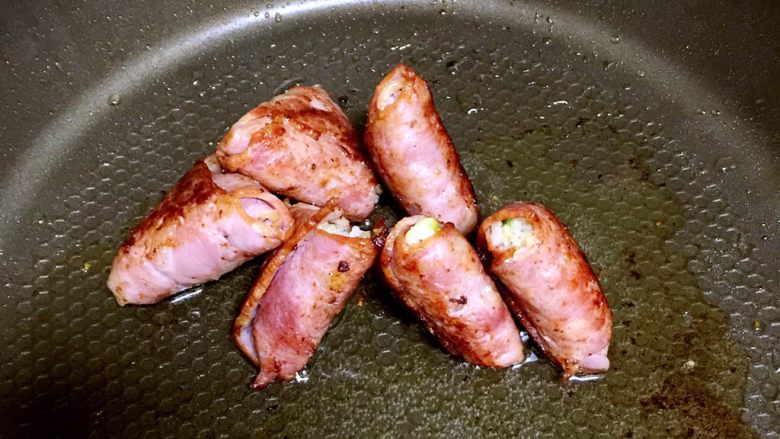 培根包饭—小小炒饭的另一种高大上吃法,两面都煎好了,把培根包饭立起来,侧面也都煎一下。