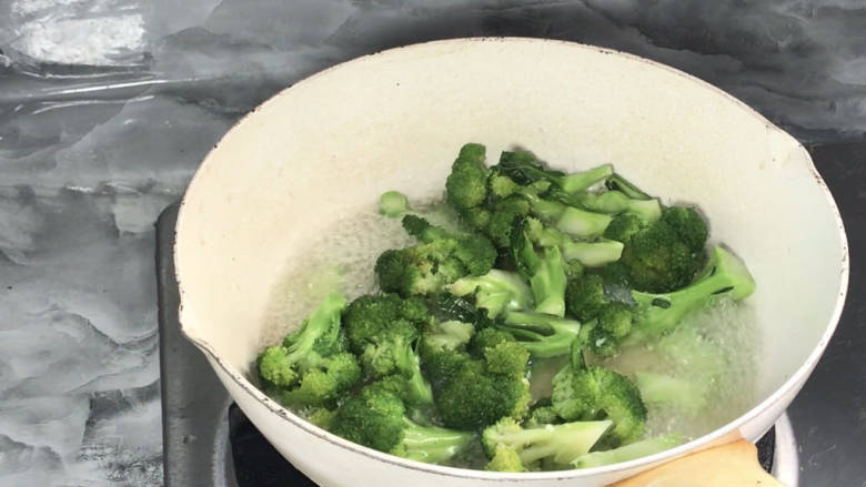 五花肉炒西兰花,放入西兰花,拌匀煮至断生,捞出备用