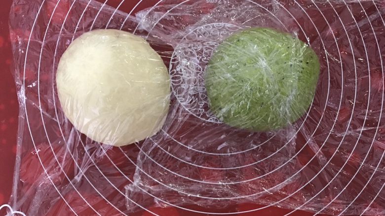 抹茶蜜豆双色吐司,取出发酵好的面团排气,揉成团,盖上保鲜膜醒发15分钟。