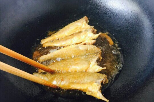 小黄鱼焖豆腐,锅里放入适量的油,小黄鱼两面裹上面糊待油6成热的时候,把裹好面糊的小黄鱼,轻轻地贴着油面放入锅里。